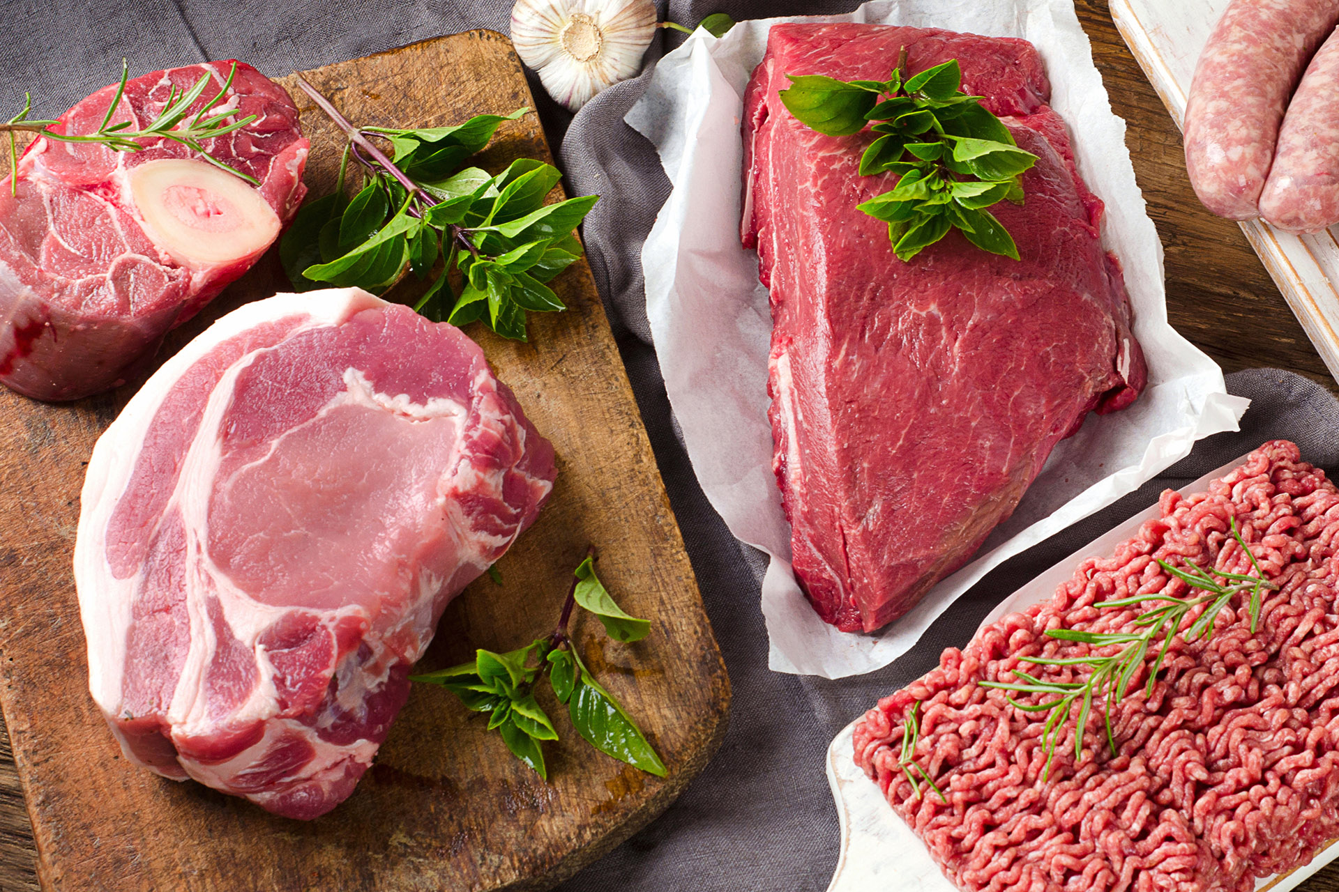 Different types of fresh raw meat on dark wooden background. 